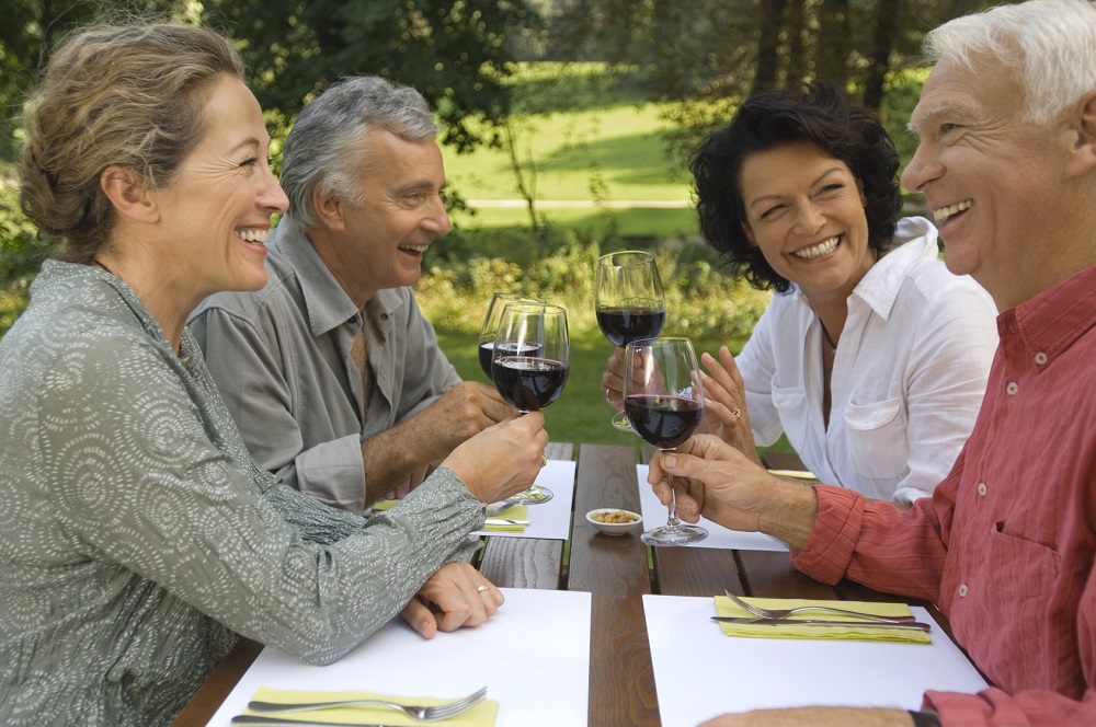 Two mature couples drinking wine