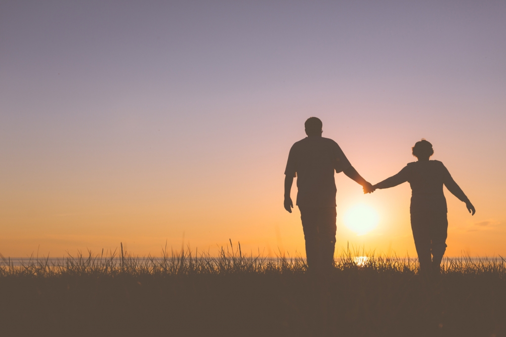 Senior couple holding hands silhouettes