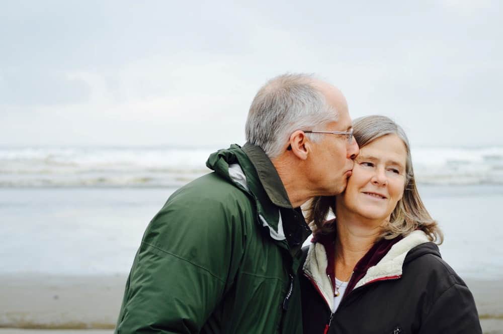 older couple kissing at the beach